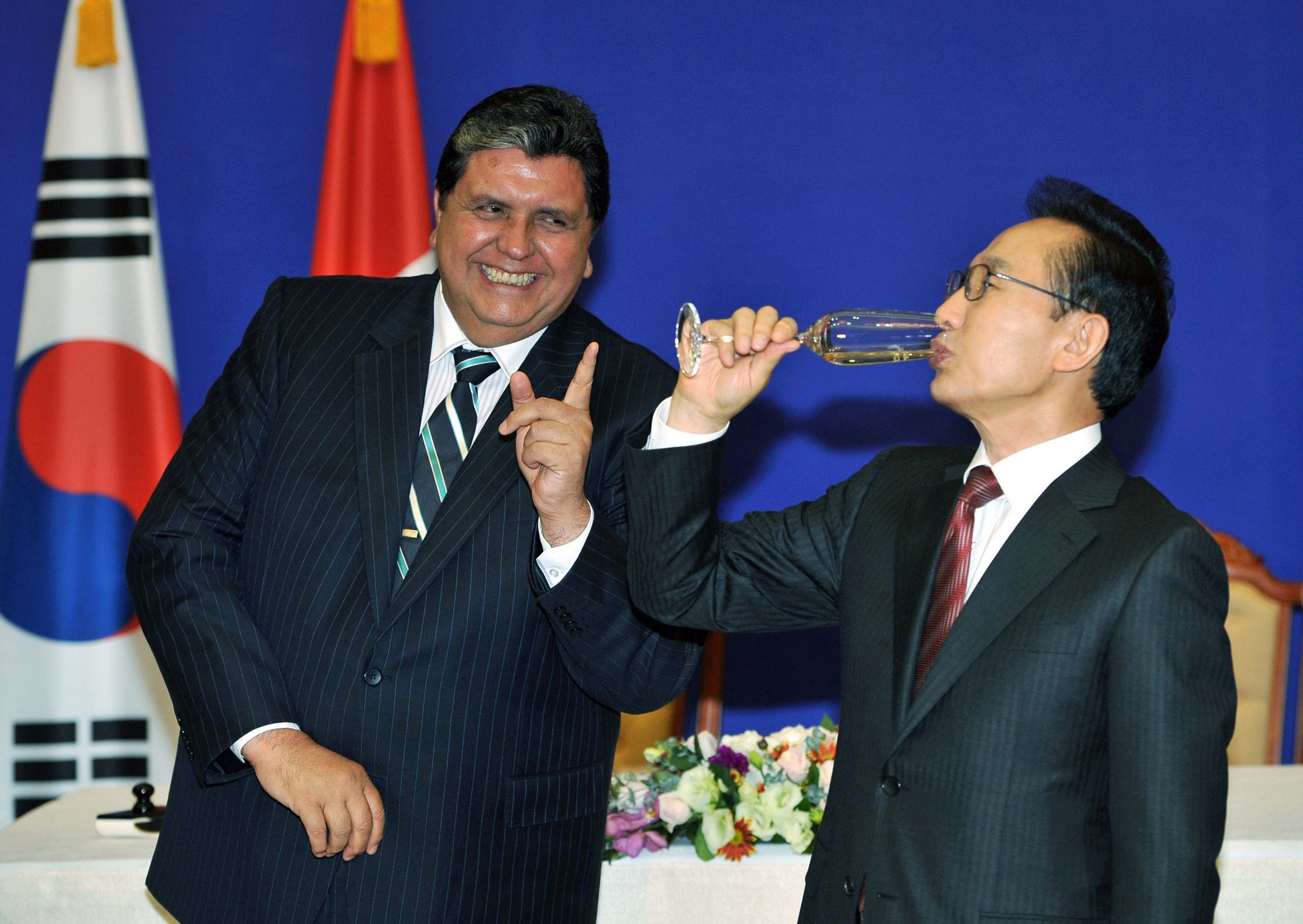 South Korea's President Lee drinks champagne as his Peruvian counterpart Garcia gestures after a signing ceremony at the presidential Blue House in Seoul