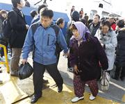 People arrive by a maritime police ship from Yeonpyeong island, at a police port in Incheon