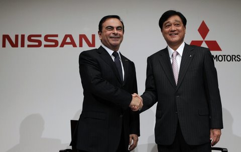 Nissan Motor's CEO Carlos Ghosn shakes hands with Mitsubishi Motors Corp.'s President Osamu Masuko at the end of a joint news conference in Tokyo