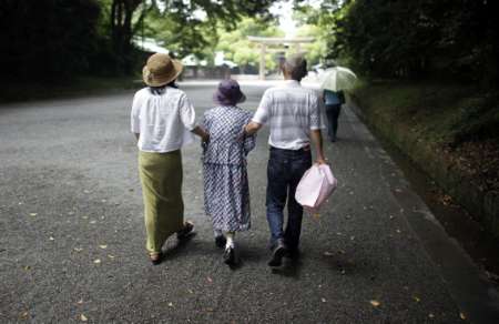 An elderly woman is led to a temple in Tokyo in this July 17, 2009 file photo. Japan is ageing far faster than any other developed country. More than a quarter of Japanese are set to be