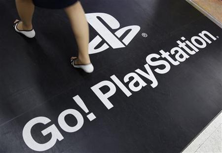 Una mujer camina sobre una alfombra de PlayStation 3 en una tienda de Tokio. PlayStation 3 en problemas.