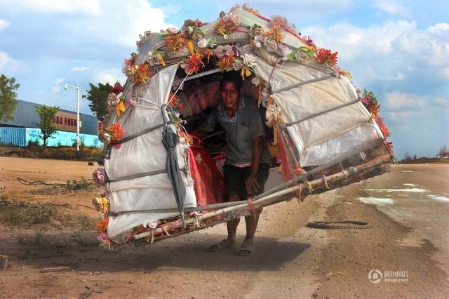 El hombre caracol y su casa decorada con flores de plástico (foto Tencent)