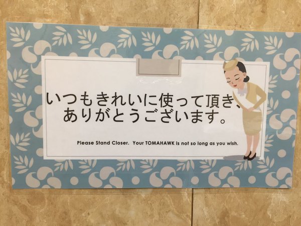 El cartel en dos idiomas en un baño (foto Twitter)