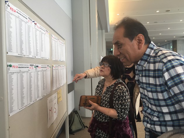 Electores peruanos buscan su mesa de votación en Yokohama.