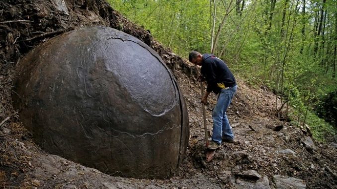 Suad Keserovic cleans a stone ball in Podubravlje village near Zavidovici