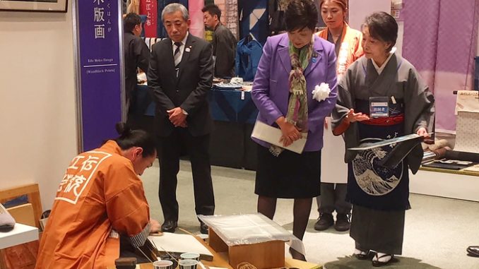 La Gobernadora Yuriko Koike observa a un artesano de Moku-hanga, la técnica de impresión con madera.