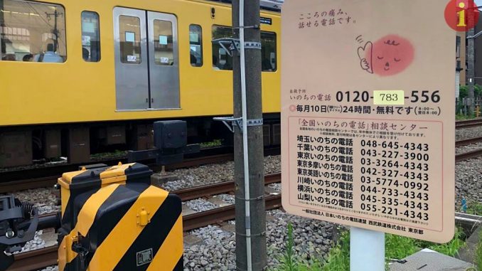 Aviso para suicidas en un paso de trenes en Tokio.