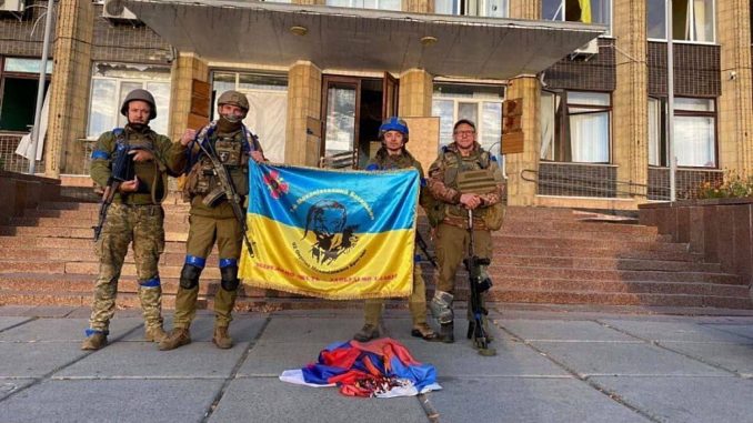 Combatientes de la brigada 92 con la bandera ucraniana en Kupyansk, región de Kharkiv.