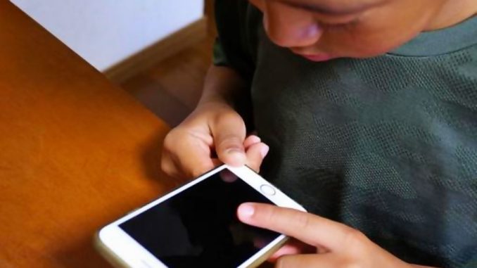 Niño viendo el celular a escondidas
