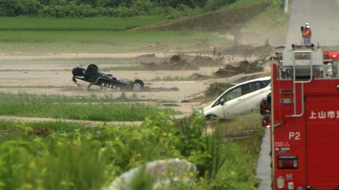 Coche patrullero arrastrado por el desborde del río Mogami en Shinjo, Yamagata