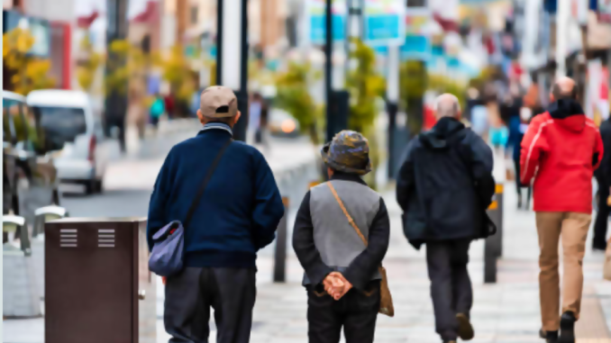 Personas mayores japonesas caminan por una calle.