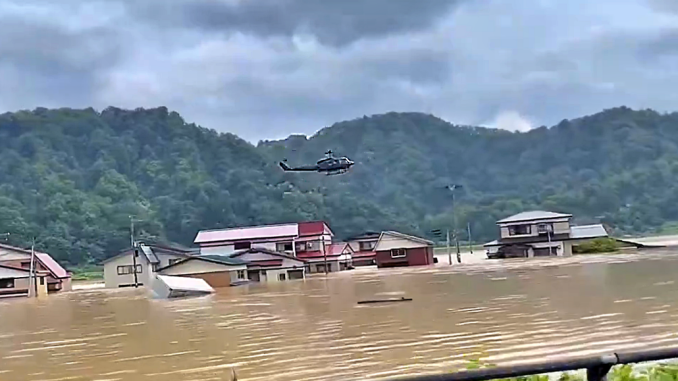 Un helicóptero militar sobrevuela la aldea de Tozawa, en Yamagata. Desborde del río Mogami.