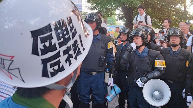La policía japonesa antidisturbios pide a los manifestantes salir de la Plaza de la Paz