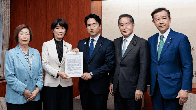 Noriko Horiuchi, presidenta del Grupo de Trabajo para la Reducción de Pérdidas de Alimentos y la Promoción de la Donación de Alimentos, y otros miembros entregan la resolución al ministro Koizumi.