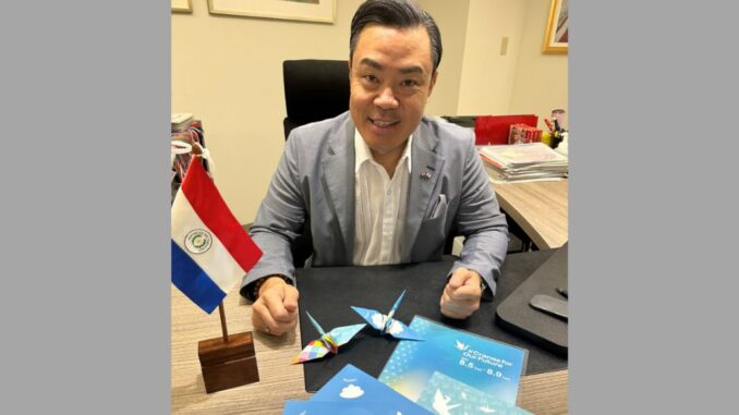 El embajador de Paraguay, Mario Toyotoshi muestra las grullas de papel plegadas como símbolo de paz.